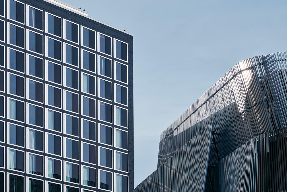 Bild på en del av Stockholm Waterfront med ett höghus i förgrunden och en blå himmel ovanför